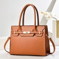 Macro detail of brown lychee grain leather with gold twist lock on stylish handbag - Earthy Yellow