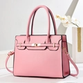 Detailed macro view of pink lychee leather texture and golden metal twist lock on handbag - Pink