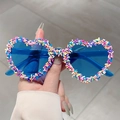 Dettaglio di occhiali da sole a cuore con lenti blu e montatura decorata a colori - Blu