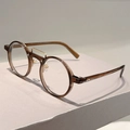 Detalle de gafas redondas retro con montura ámbar y doble puente de metal dorado - Montura Marrón Transparente Lente Transparente