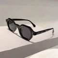 Detail of polygonal black sunglasses with dark lenses on a geometric podium - Black Frame Grey Lens