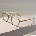 Détail de montures rondes beige avec un double pont distinctif en métal doré élégant - Monture Café Verres Transparents
