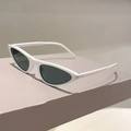 Detail shot of white cat-eye sunglasses with dark lenses on a minimalist geometric block - White Frame Gray