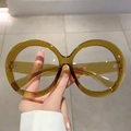 Macro shot of oversized round amber resin glasses frame with visible metal hinges - Amber