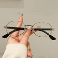 Oval silver metal frame sunglasses with black temples held in a person's hand - Silver Frame Clear Lens