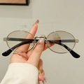Hand holding silver metal oval sunglasses with retro round frames and black tips - Silver Frame Silver Mirror Lens