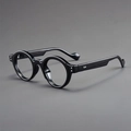 Close-up of retro round glasses frame featuring glossy black finish and silver rivets - Black Frame Clear Lens
