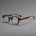 Detail view of round glasses with glossy black frame and tortoiseshell patterned temples - Grey Frame Clear Lens Tortoise Legs