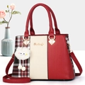 Red and beige patchwork handbag with plaid side panels and a white fuzzy pompom charm - Red