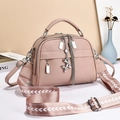 Détail du sac en cuir souple avec breloque chien ballon et bandoulière large à motifs - Rose