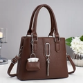 Dunkelbraune Handtasche aus Leder mit Litschistruktur, silberner Schnalle und Troddel - Kaffeebraun