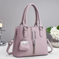 Detail view of lavender faux leather handbag with silver hardware and tassel charm - Purple