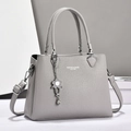 Light gray pebbled leather handbag with silver hardware and floral charm pendant - Gray