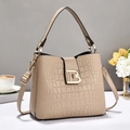 Detail view of beige crocodile embossed bucket bag featuring elegant TB gold buckle - Light Khaki