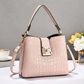 Détail de la texture en cuir crocodile rose et fermoir doré logo B sur un sac à main - Rose