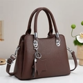 Brown lychee leather tote bag with silver hardware and star pendant on a gray background - Coffee