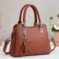 Sac fourre-tout en cuir marron avec chaîne argentée et étoile sur une table blanche - Jaune Terre