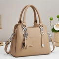 Beige pebble leather handbag with dual handles and crossbody strap in elegant studio setting - Khaki