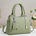 Close-up of light green litchi texture leather tote with star pendant and silver hardware - Green