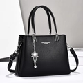 Borsa tote nera in pelle martellata con ciondolo a fiore e tracolla regolabile - Nero