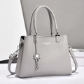 Hellgraue Shopper-Tasche aus Leder mit Lychee-Muster und Blumenanhänger - Grau