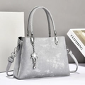 Chic light gray leather handbag with floral rhinestone charm and adjustable shoulder strap - Gray