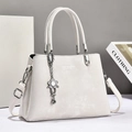 Elegant white matte leather tote bag with silver flower charm and adjustable shoulder strap - Off-white