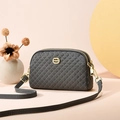 Petit sac bandoulière gris matelassé avec logo doré et sangle sur fond rose pastel - Gris