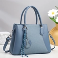 Dettaglio borsa celeste in pelle PU con cuciture a spina di pesce e nappa decorativa - Blu