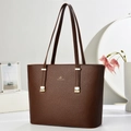 Macro detail of dark brown litchi leather tote bag with gold logo and hardware - Coffee