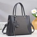 Sac à bandoulière gris foncé avec design patchwork et breloque sur fond minimaliste - Gris