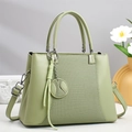 Détail du sac à main vert sauge avec texture tressée, coutures en zigzag et pendentif - Vert