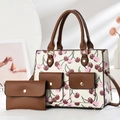 Detail of cherry print tote bag with brown faux leather pockets and matching envelope wallet - White