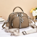 Chic khaki pebbled leather crossbody bag with wide V-pattern strap and silver charms - Khaki