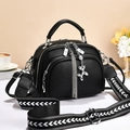 Fashionable black pebble leather crossbody bag with wide shoulder strap and tassel charm - Black
