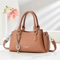 Brown lychee leather handbag with heart pendant and soft aesthetic lighting - Pink