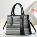 Rainbow woven tote bag with black leather accents and silver hardware on white display stand - Grey White Stripe With Black (Black 1)