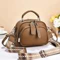 Borsa marrone in pelle con ampia tracolla a fantasia su sfondo beige - Marrone
