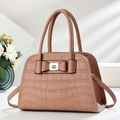 Detail of pink crocodile embossed tote bag with elegant bow and metal logo accents - Pink