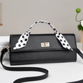 Elegant black lychee leather crossbody bag with gold lock and polka dot scarf detail - Black