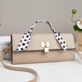 Detail of beige litchi leather handbag with polka dot scarf and golden metal lock - Khaki