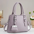 Détail du sac cabas en cuir lilas à grain lychee avec charm mini sac et boucles argentées - Violet
