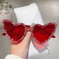 Gros plan de lunettes de soleil en cœur avec strass rouges et un étui blanc - Lentilles Rouges Base Argentée Strass Rouge