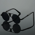 Détail de lunettes de soleil rondes montrant le double pont et le design en métal texturé - Monture Noire Verres Noirs