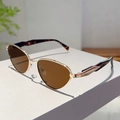 Detail einer goldenen Katzenaugen-Sonnenbrille mit dunklen Schildpatt-Bügeln auf weißem Pult - Goldrahmen Teegläser Leopardenbügel