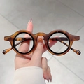 Primer plano de gafas redondas vintage con textura de carey pulida y acabado brillante - Leopardo Mate Marco Negro Lente Transparente
