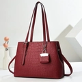 Deep red crocodile embossed tote bag with a matching mini charm in a minimalist studio setting - Wine Red