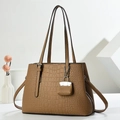 Detailansicht der braunen Kroko-Tasche mit silbernem Schloss und kleinem Beutel - Braun