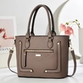 Detailed macro view of brown pebbled leather texture and golden hardware on the handbag - Gray