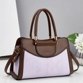 Detailansicht der kontrastfarbenen Handtasche mit Schlangenmuster und goldenen Details - Lila